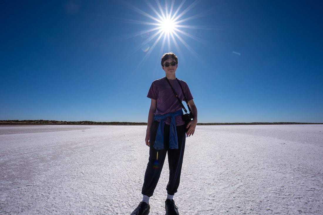 A teeanger standing on a salt flat in Australia.